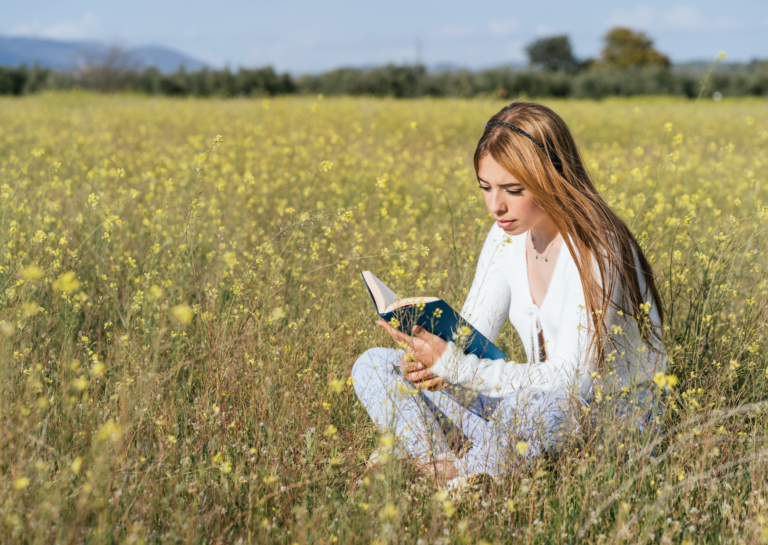 Girl sat in a field reading